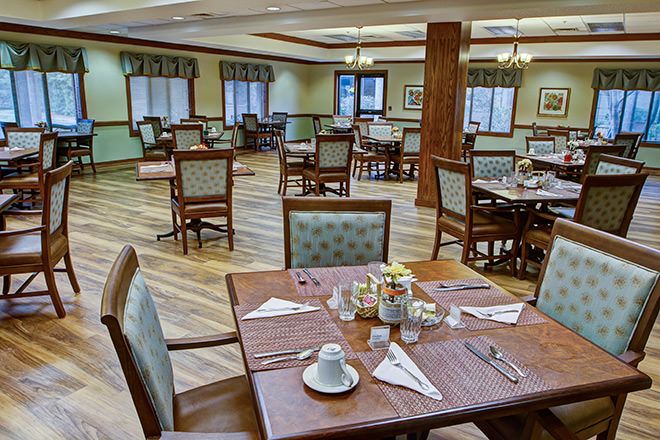 An empty dining room with neatly arranged tables and chairs, ready for service.