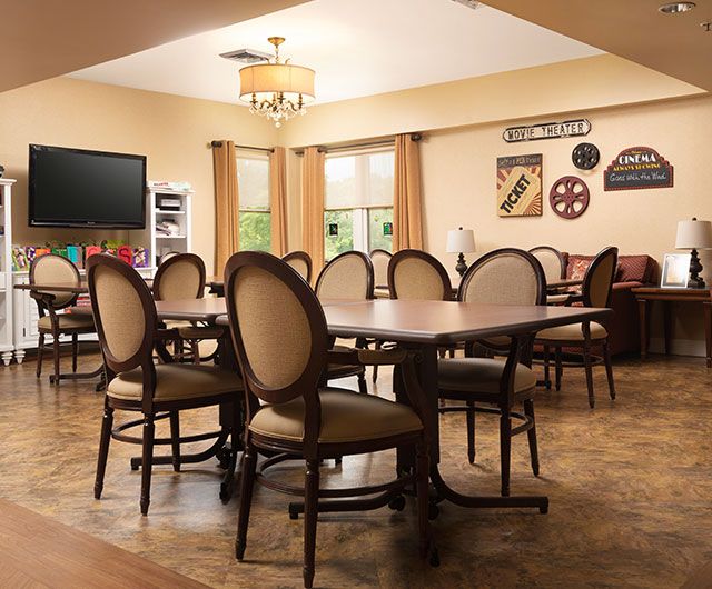A well-decorated dining room with elegant chairs and tables, adorned with wall decorations and warm lighting.