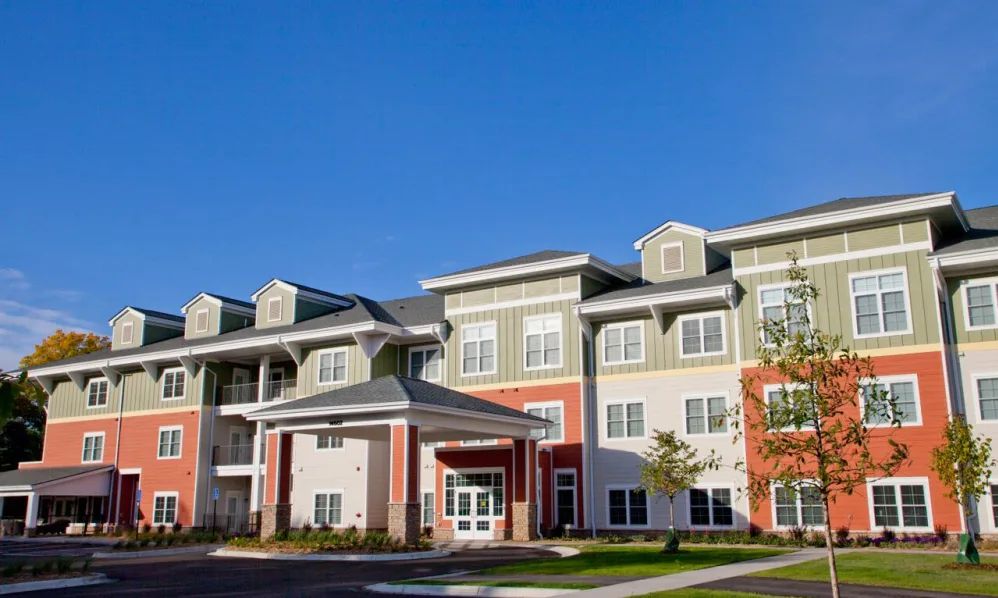 A modern residential apartment building under a clear blue sky.