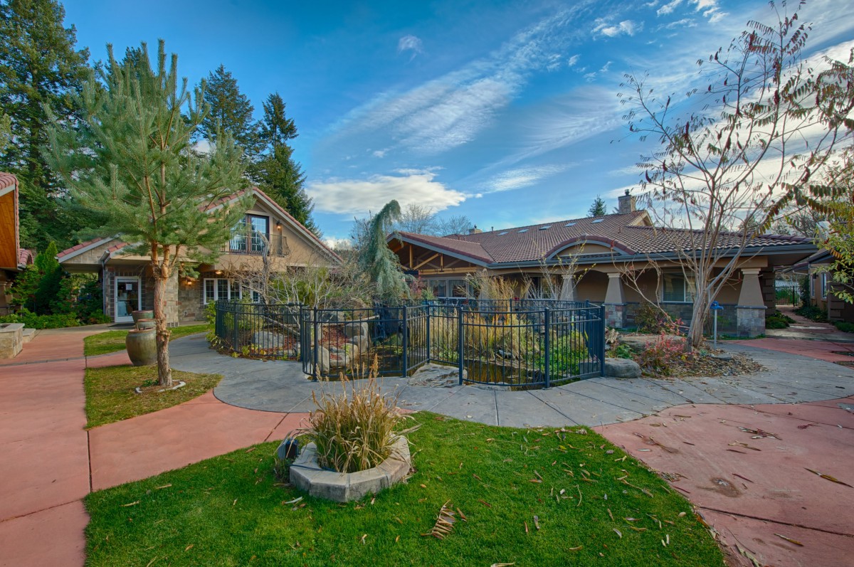 A charming house with a well-maintained garden under a clear blue sky.