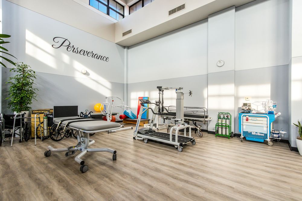 A spacious physical therapy room equipped with various exercise and rehabilitation equipment.