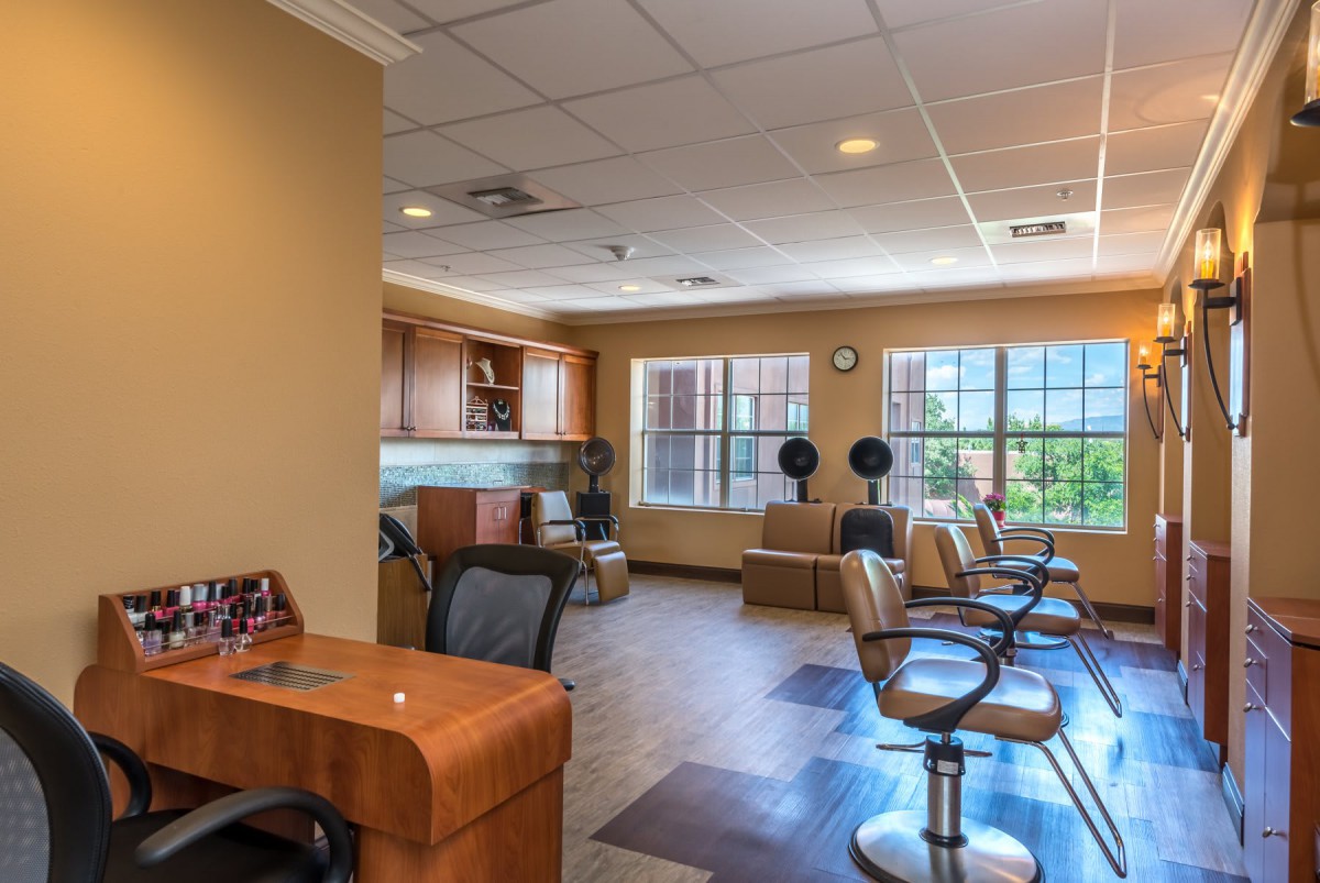 A well-lit beauty salon interior with styling stations and comfortable seating.