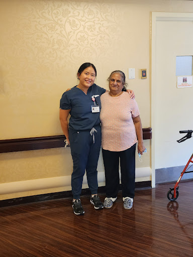 A caregiver and an elderly woman pose together, celebrating companionship and care.
