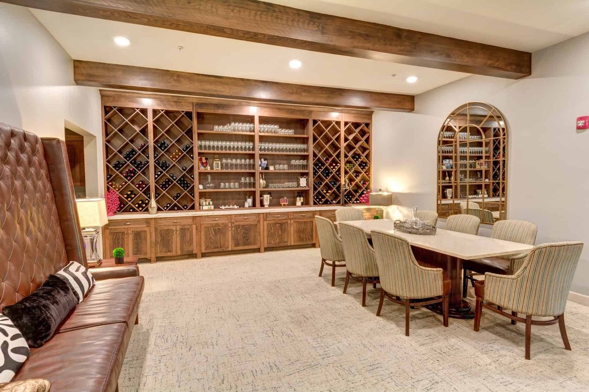 A cozy library and wine cellar combination with elegant wooden furniture and ample shelving.