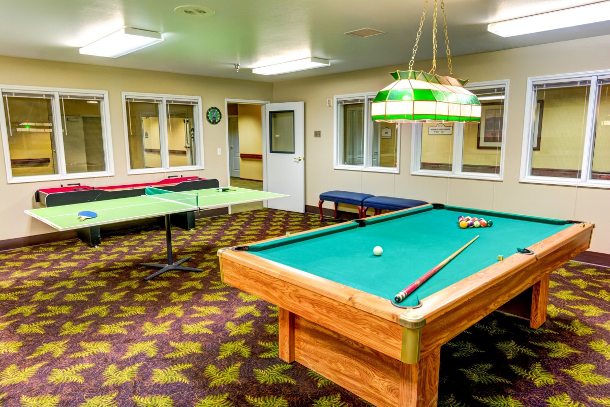 A recreational game room featuring both a pool table and a ping pong table.
