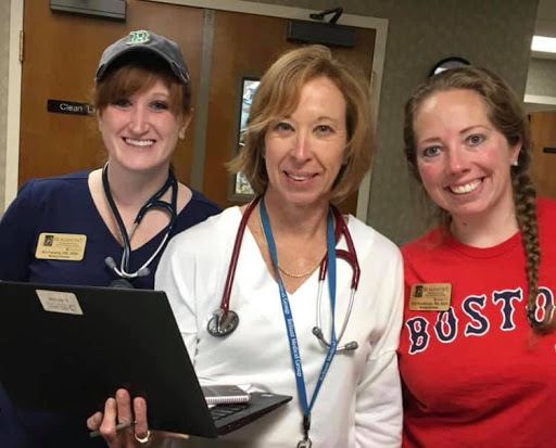 A team of healthcare professionals posing together in a hospital setting.