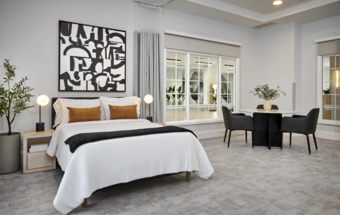 A modern bedroom with sleek furnishings and abstract artwork.