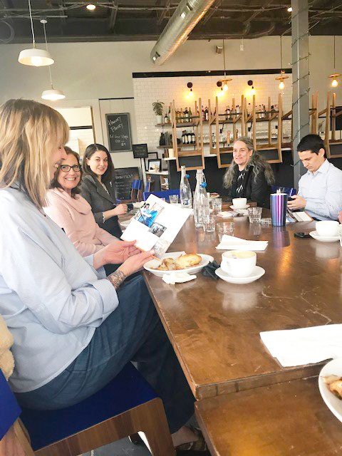 A group of people having a meeting in a cafe, engaged in discussion.