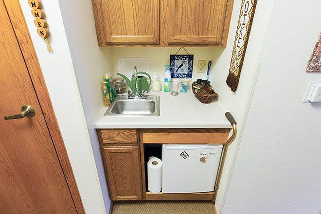 A compact kitchen area with a sink, cabinets, and countertop in a small space.