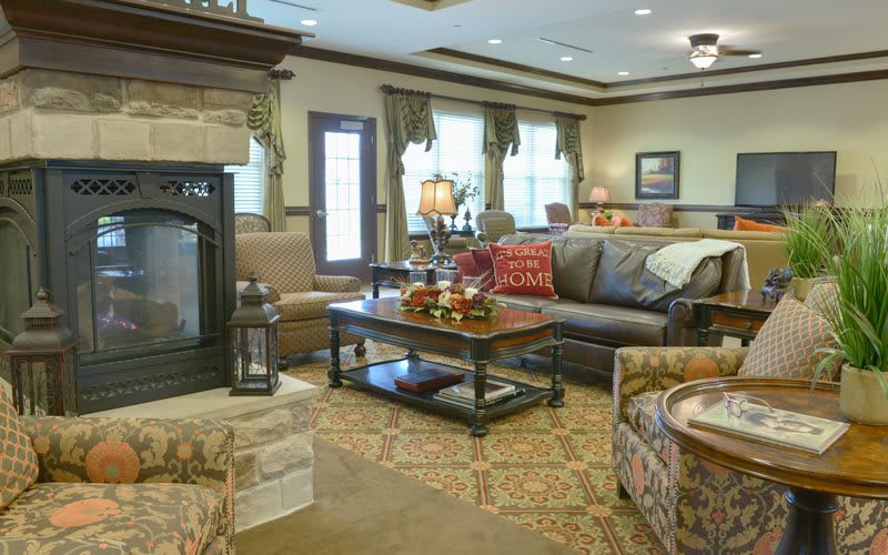 A cozy living room featuring a sofa, armchairs, a fireplace, and elegant decor.