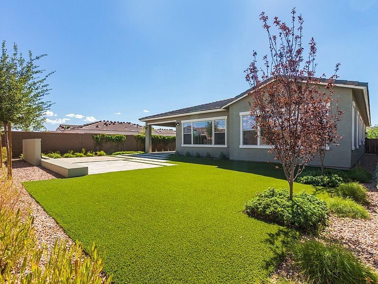 A suburban house with a well-maintained lawn and landscaping.
