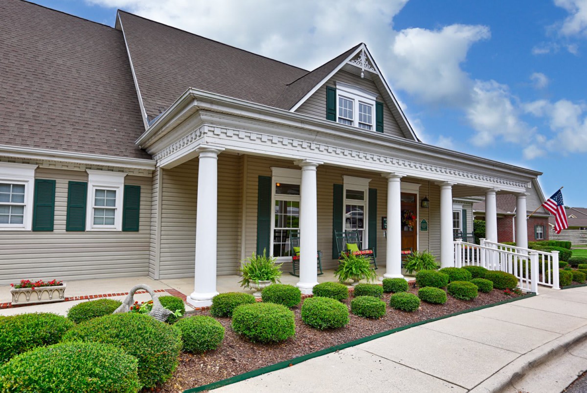 A beautiful residential home with a welcoming porch and well-maintained landscaping.