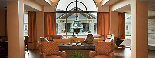 A cozy living room with elegant furnishings and a view of an outdoor fountain.