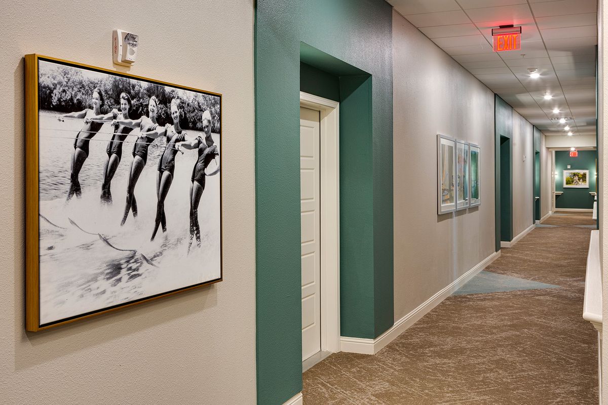 A modern hallway displaying framed artwork on the walls, with a minimalist interior design.