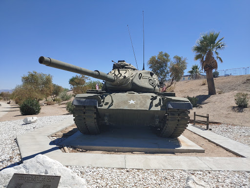 A static display of a military tank under a clear blue sky.