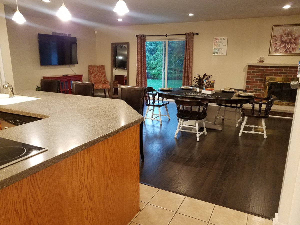 A spacious open-concept kitchen and dining area with wooden flooring and modern furnishings.