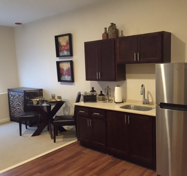 A modern kitchen with dark cabinetry and stainless steel appliances.