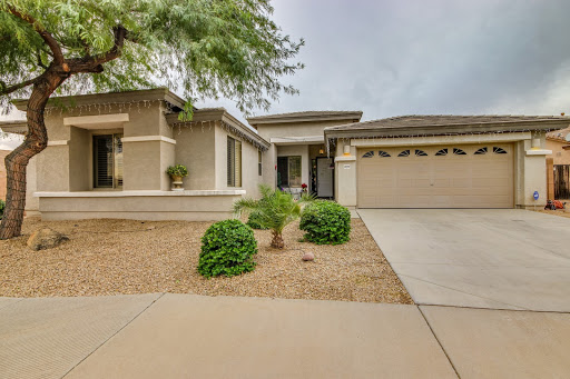 A modern suburban house with a landscaped front yard and a single-car garage.