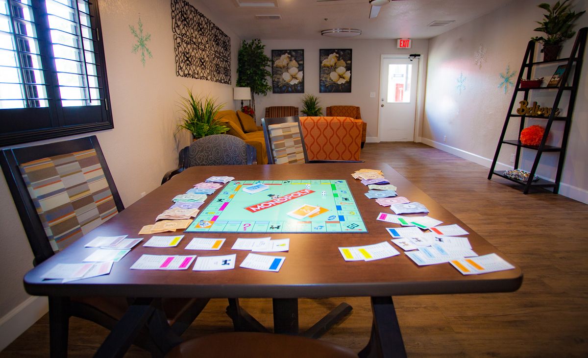 A living room setup with a Monopoly board game ready to play on the table.