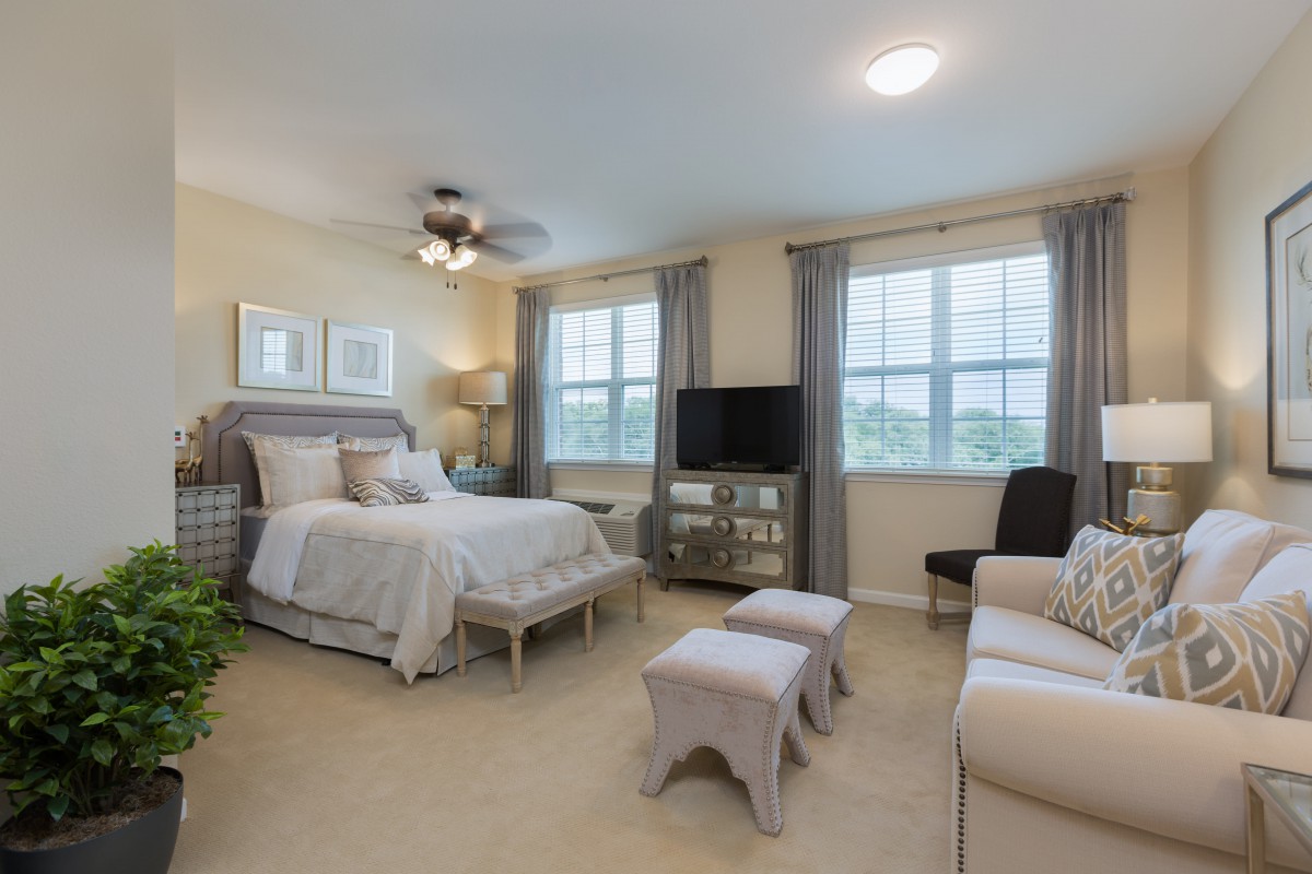 A cozy bedroom with elegant furniture and large windows.