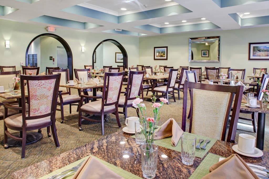 Empty restaurant dining room with neatly arranged tables and chairs.