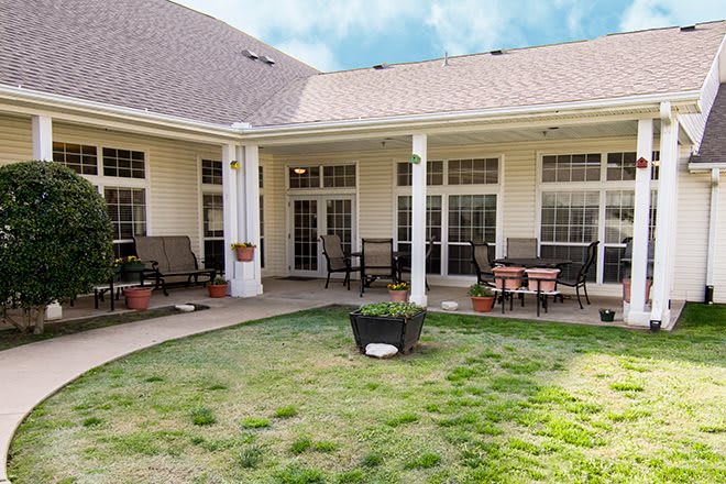 A cozy backyard patio with outdoor seating and a well-maintained lawn.