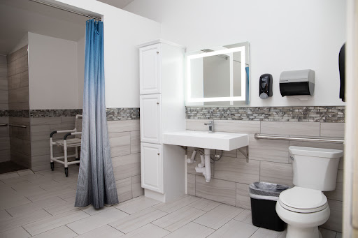 A modern, clean bathroom featuring a sink, toilet, and storage cabinets.