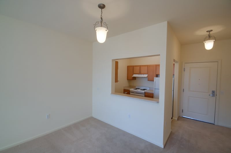A view of an empty apartment with a small kitchen and an open living area.