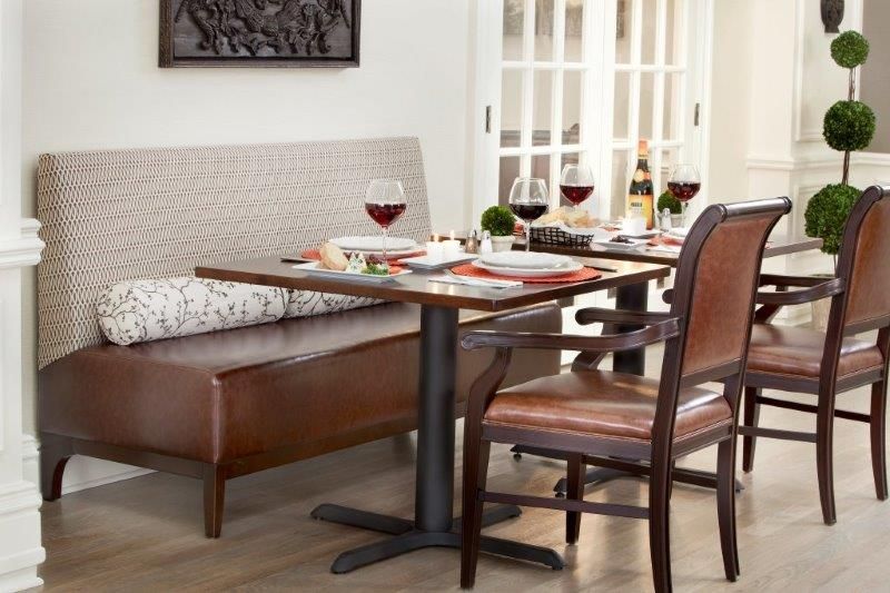 A cozy dining setup with a wooden table, wine glasses, and a mix of bench and chair seating.