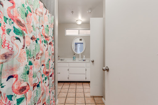 A view of a bright and tidy bathroom featuring a colorful shower curtain and a clean vanity area.