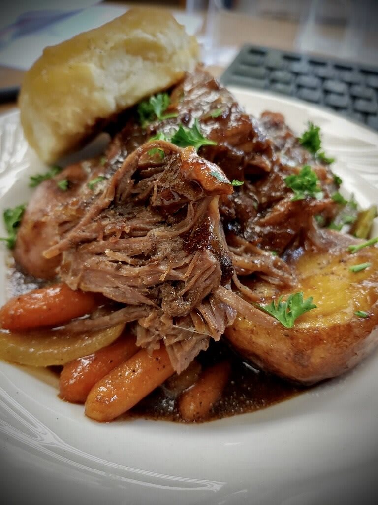 A deliciously tender pot roast served with carrots and a rich gravy.
