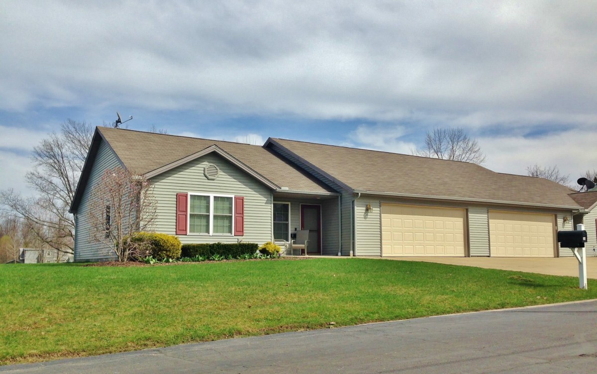 A suburban one-story house with a well-maintained lawn and attached garage.