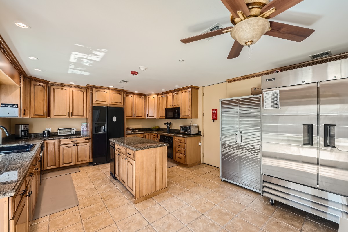 A spacious kitchen with wooden cabinets, a central island, and modern appliances.