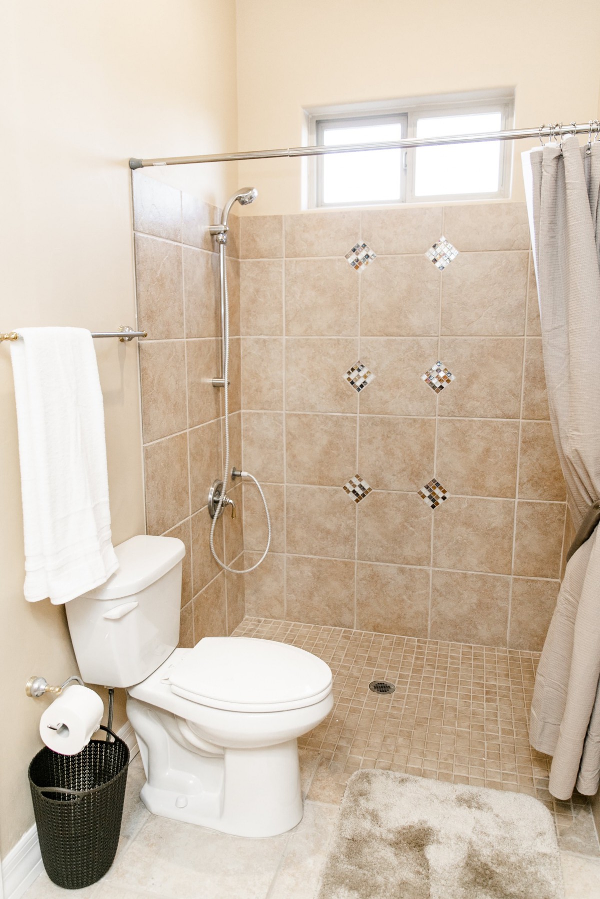 A modern bathroom with a tiled shower and toilet.