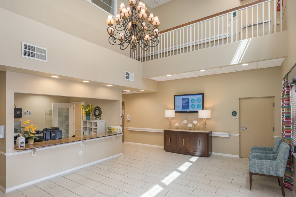 Spacious lobby area with elegant chandelier and reception desk.