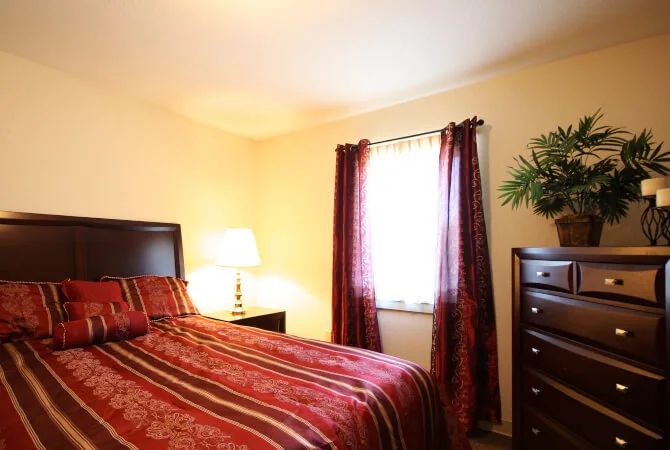 A cozy bedroom with warm lighting and red accents.