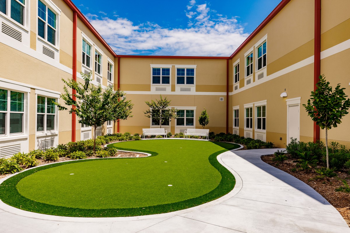 A sunny courtyard in a school building featuring a well-maintained landscape.