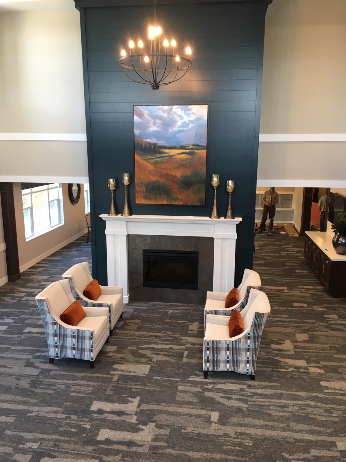 A welcoming lobby interior featuring a fireplace, comfortable seating, and decorative artwork.