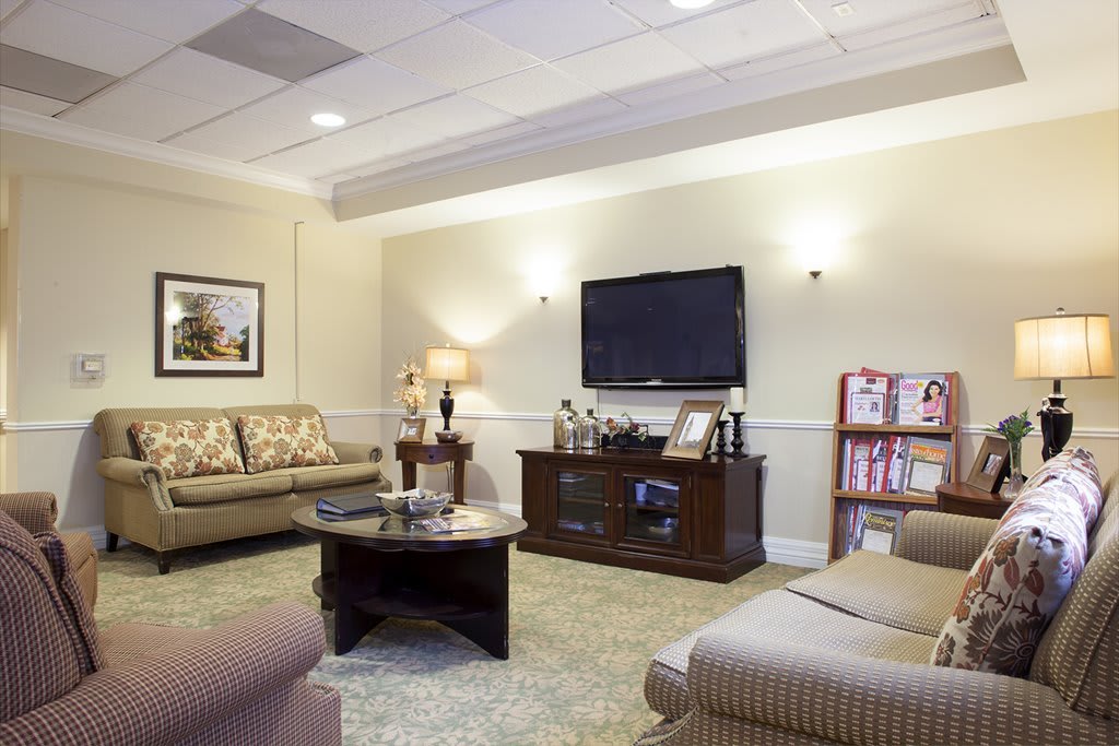 A cozy living room with comfortable seating, a large television, and tasteful furnishings.