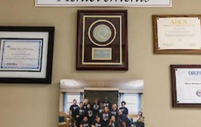A display of awards and group photo on a wall dedicated to achievements.