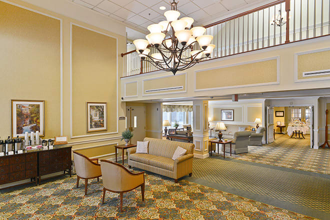 A classic hotel lobby with elegant furnishings and a large chandelier.