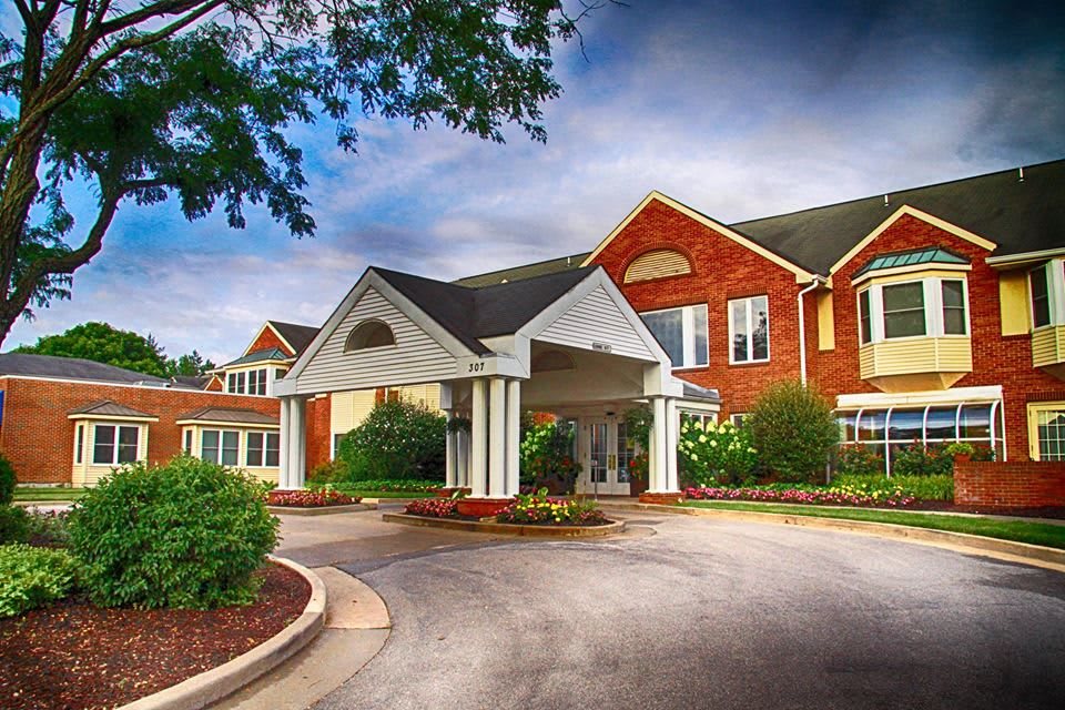 A residential building with a covered entrance and landscaped surroundings.