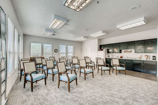 An empty conference room with rows of chairs and fluorescent lighting.