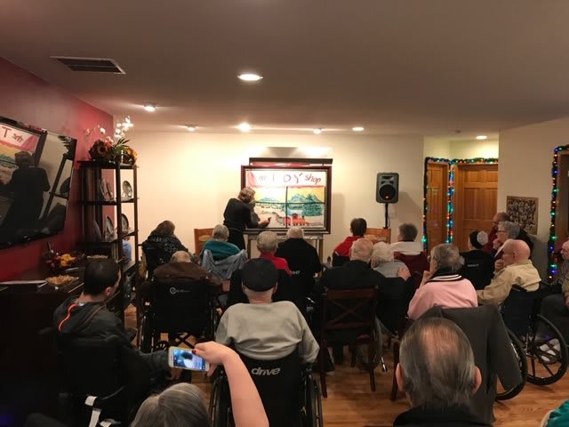 An indoor event with people seated, attentively watching a presentation.