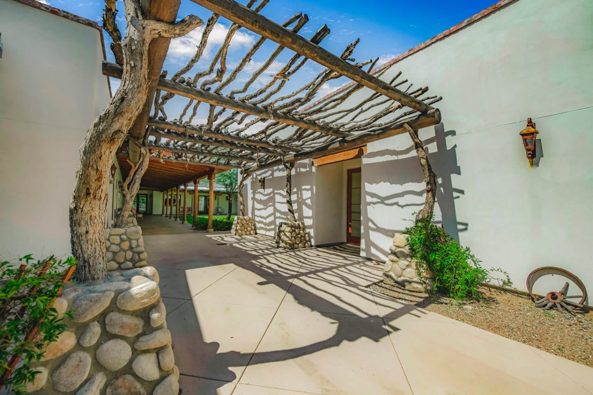An outdoor pergola casting intricate shadows on a sunny day.
