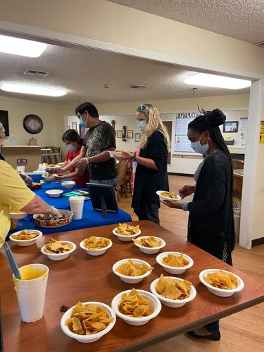 Volunteers serving food at a community dinner event.
