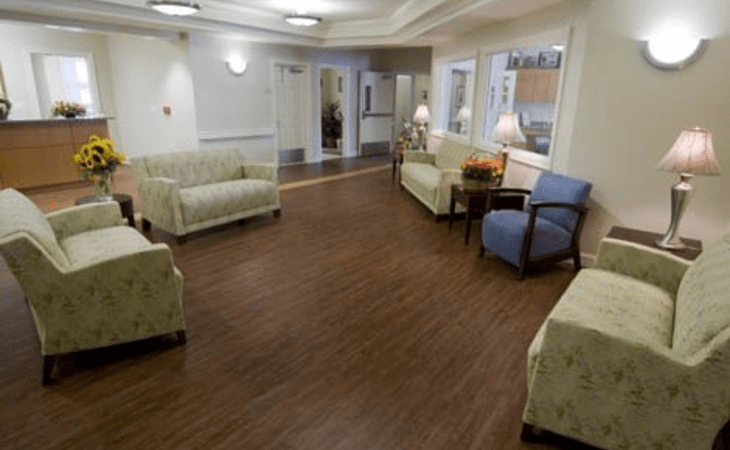 A spacious waiting room with comfortable seating and a wooden floor.