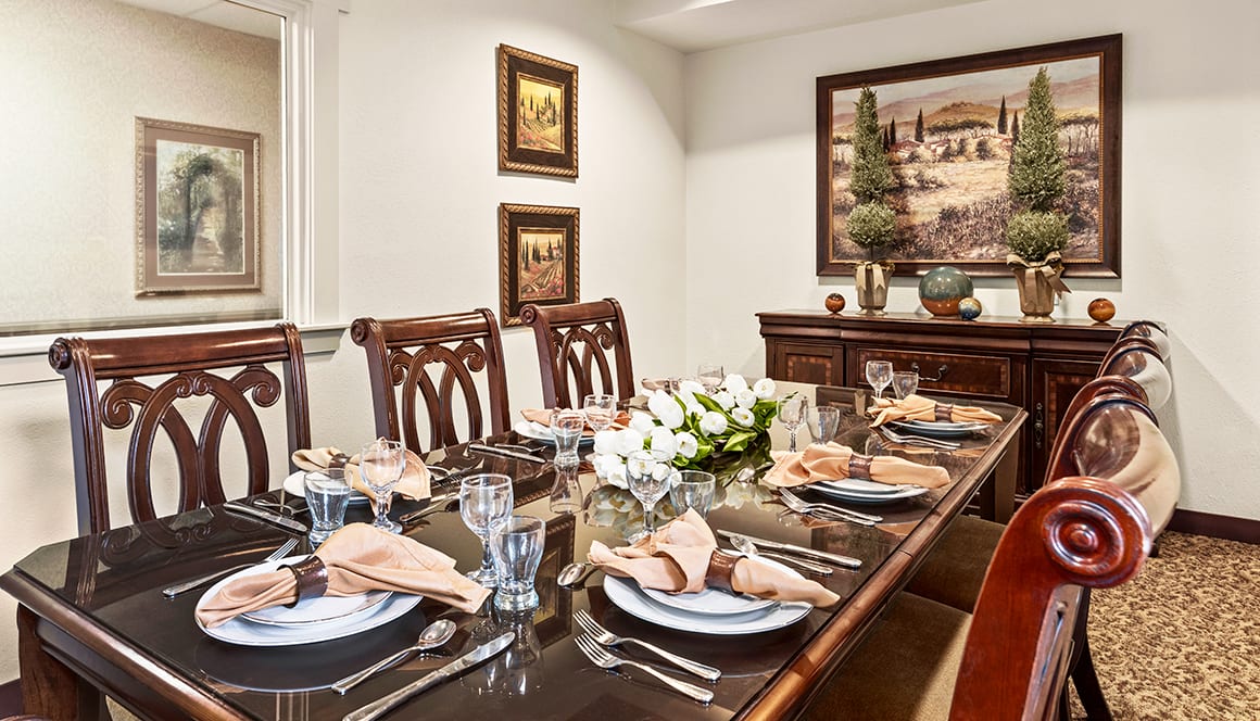 An elegantly set dining room table with stylish decor and artwork on the walls.