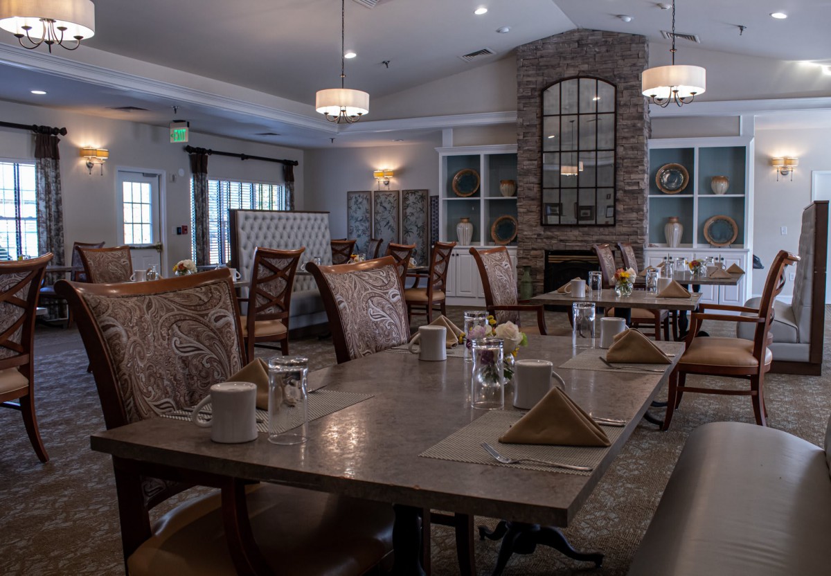 An elegant dining room with neatly set tables and comfortable chairs, ready for guests.
