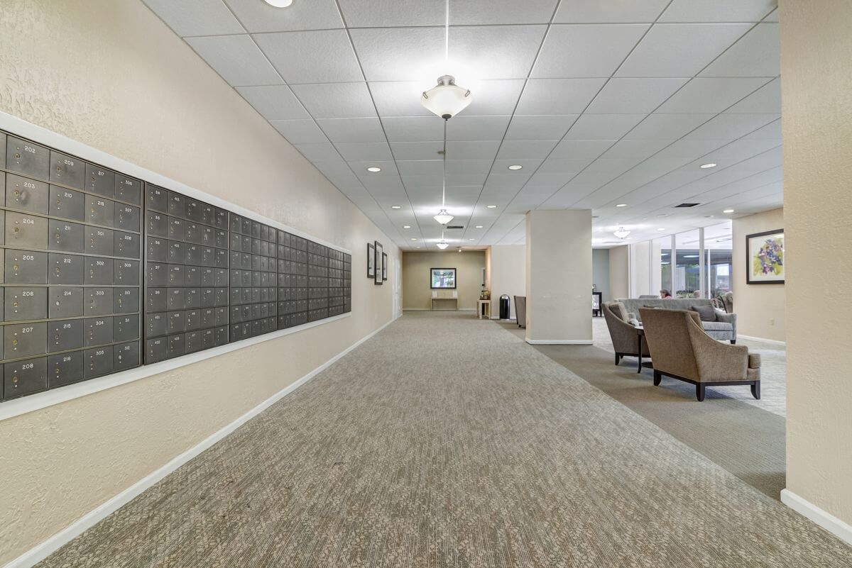 A modern lobby with a carpeted hallway and seating area.